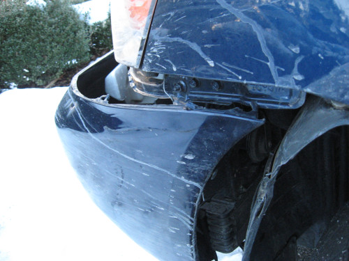Some damage to a blue vehicle from some snowy weather