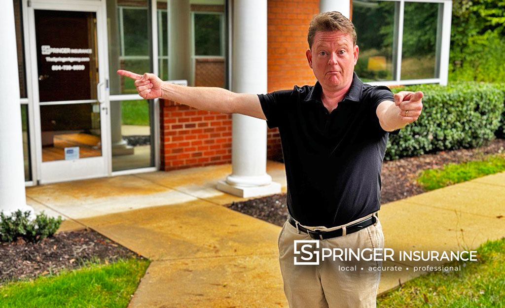 Chris is looking into the wind and pointing to the eye of the storm with his right arm